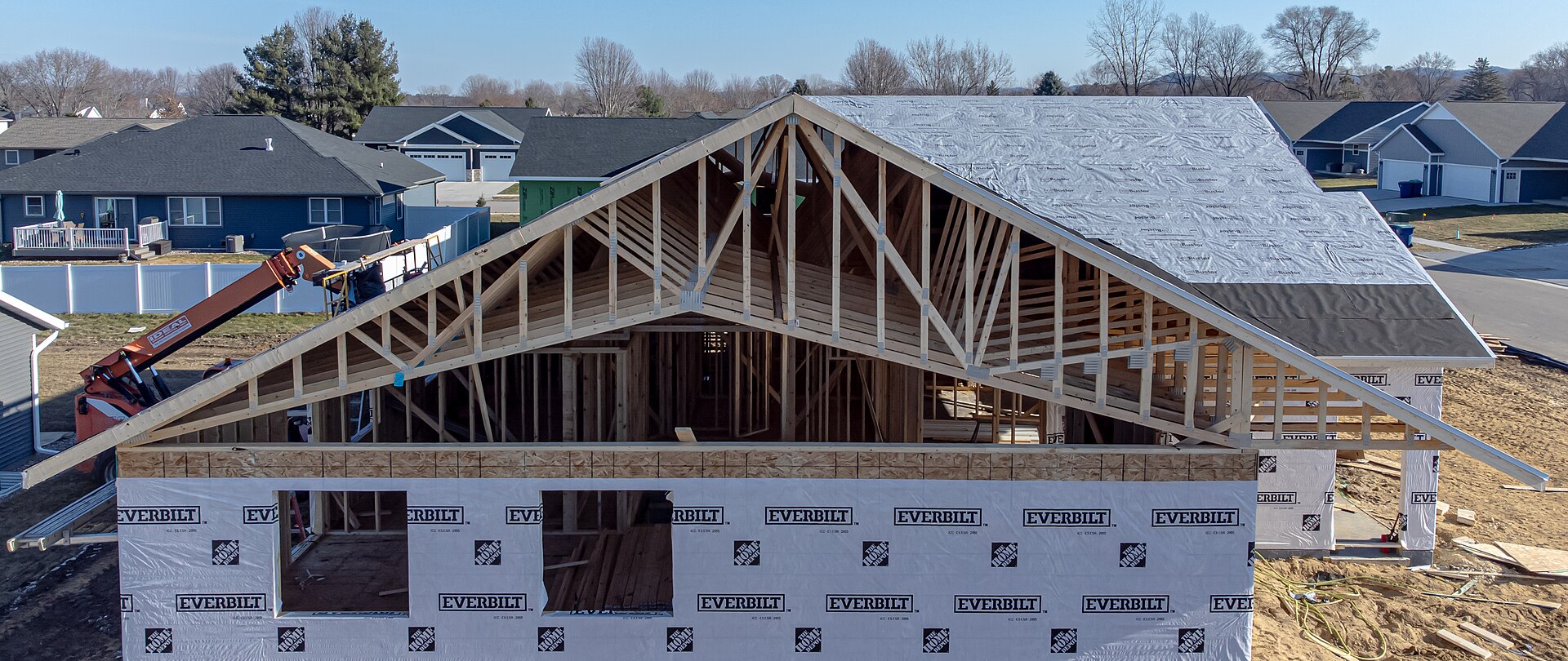 Wide front view of engineered wood roof trusses on a new house