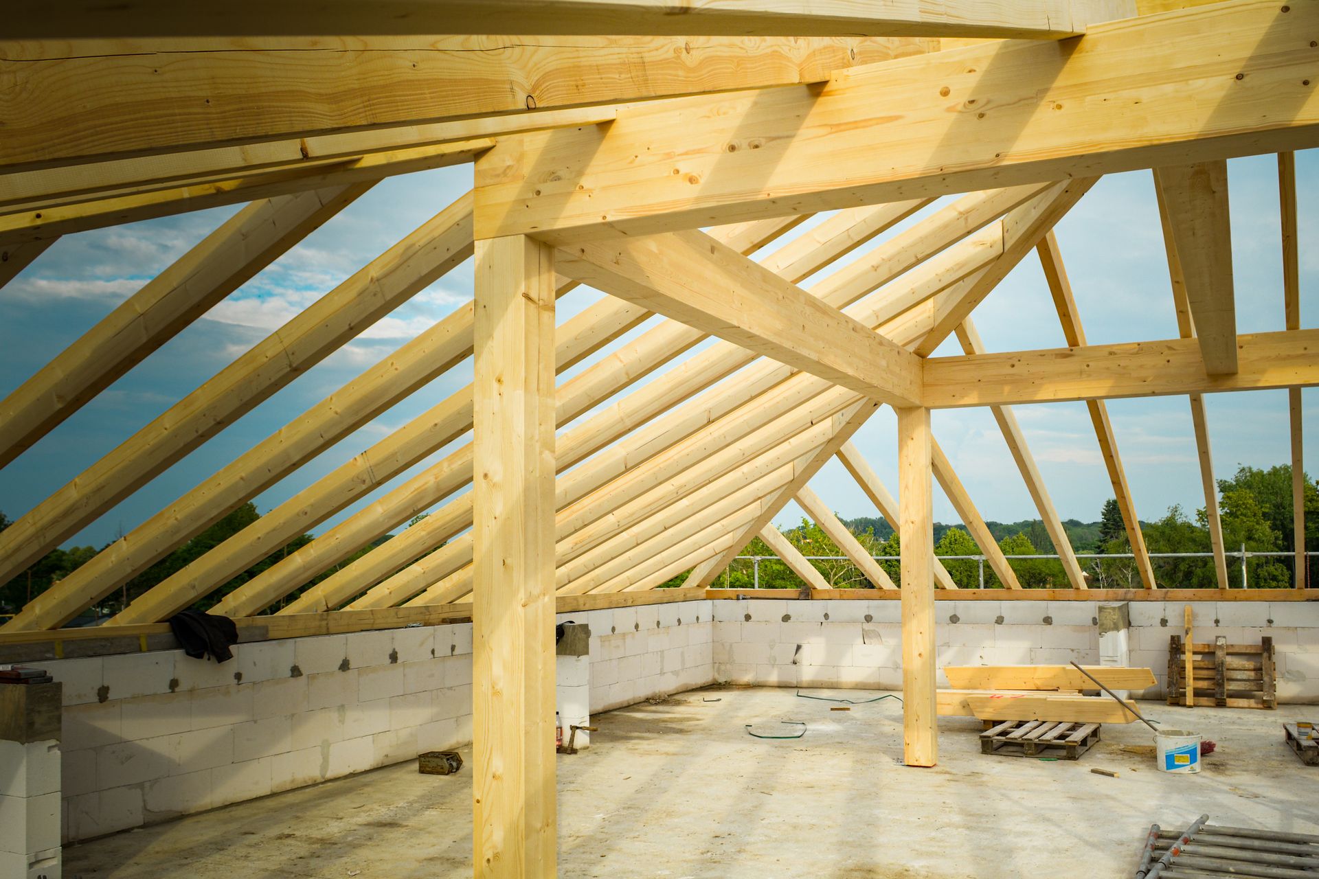 Wide view of individual wood roof rafters being framed on site
