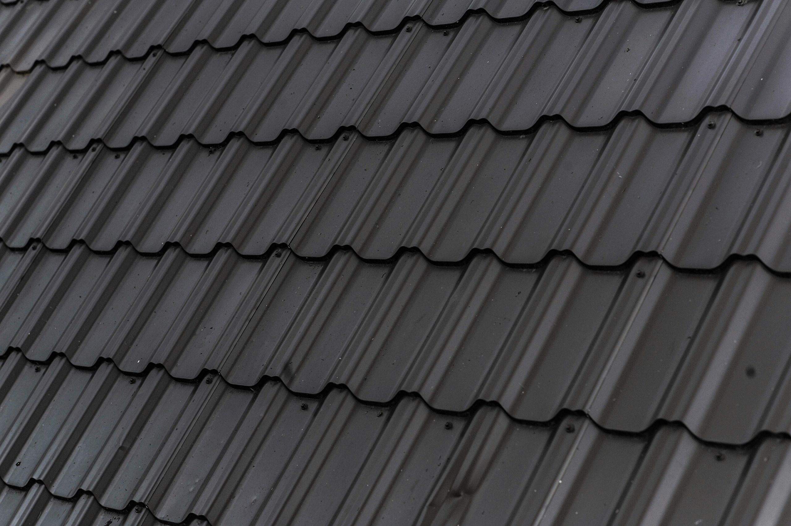 Close-up of dark stone-coated steel roofing tiles