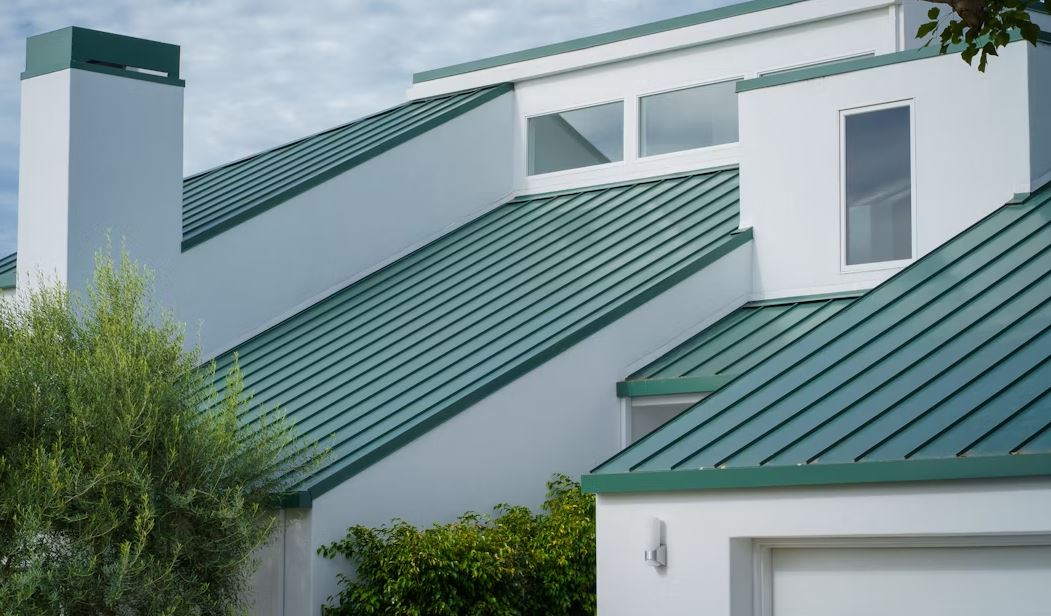 Green standing seam metal roof on a modern white San Diego home
